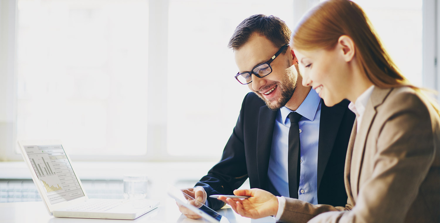 Un uomo e una donna consultano grafici di andamento sul tablet.