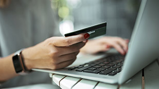 Giovane donna paga i propri acquisti online con carta di credito.