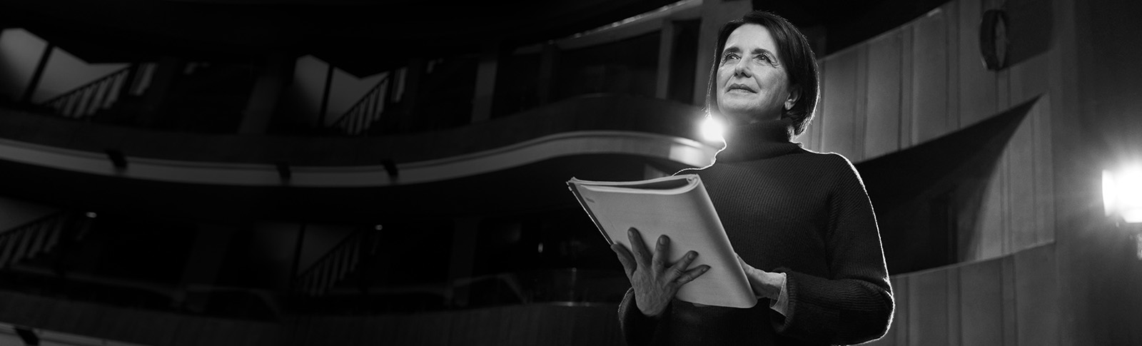 Donna legge un copione a teatro.