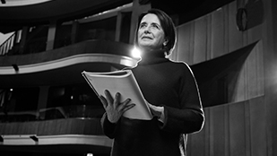 Donna legge un copione a teatro.